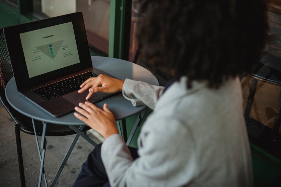 Woman analyzing sales funnel diagram on laptop at outdoor cafe emphasizing pipeline strategy