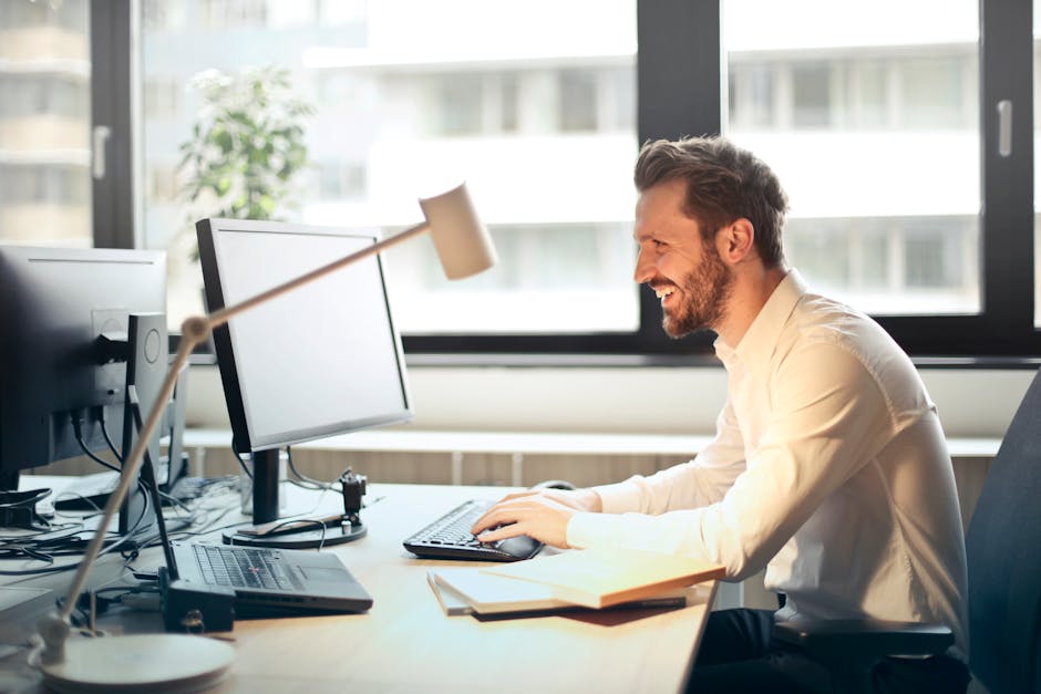 Professional man smiling at computer screen representing successful cold email outreach