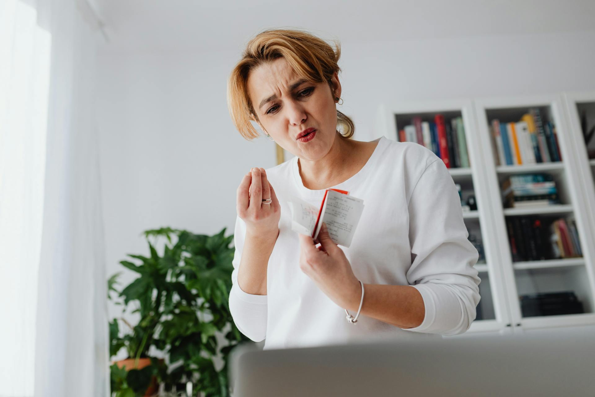 Surprised and upset woman holding receipts showing budget stress