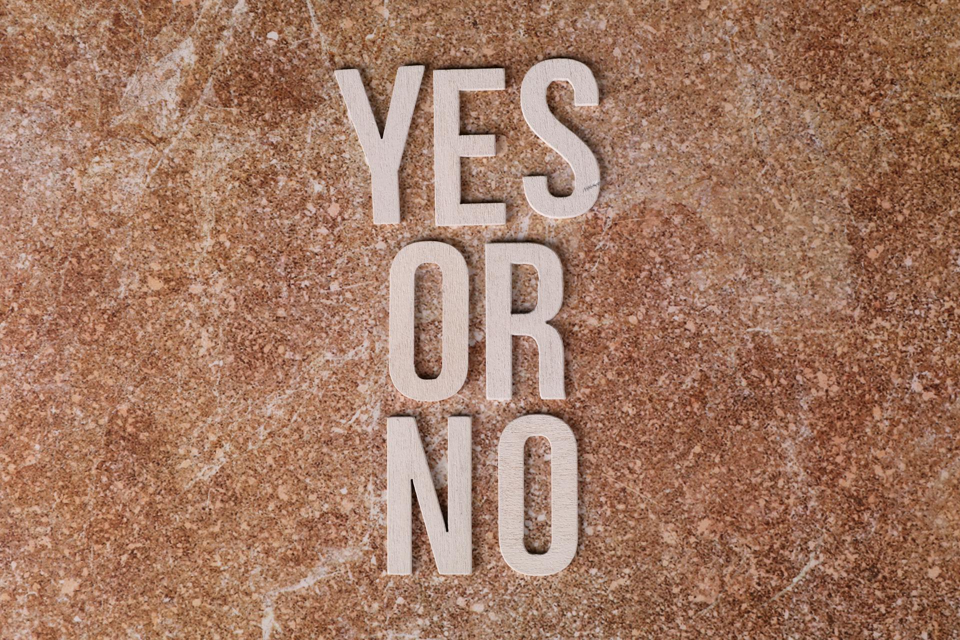 Wooden letters spelling YES OR NO symbolizing software choices