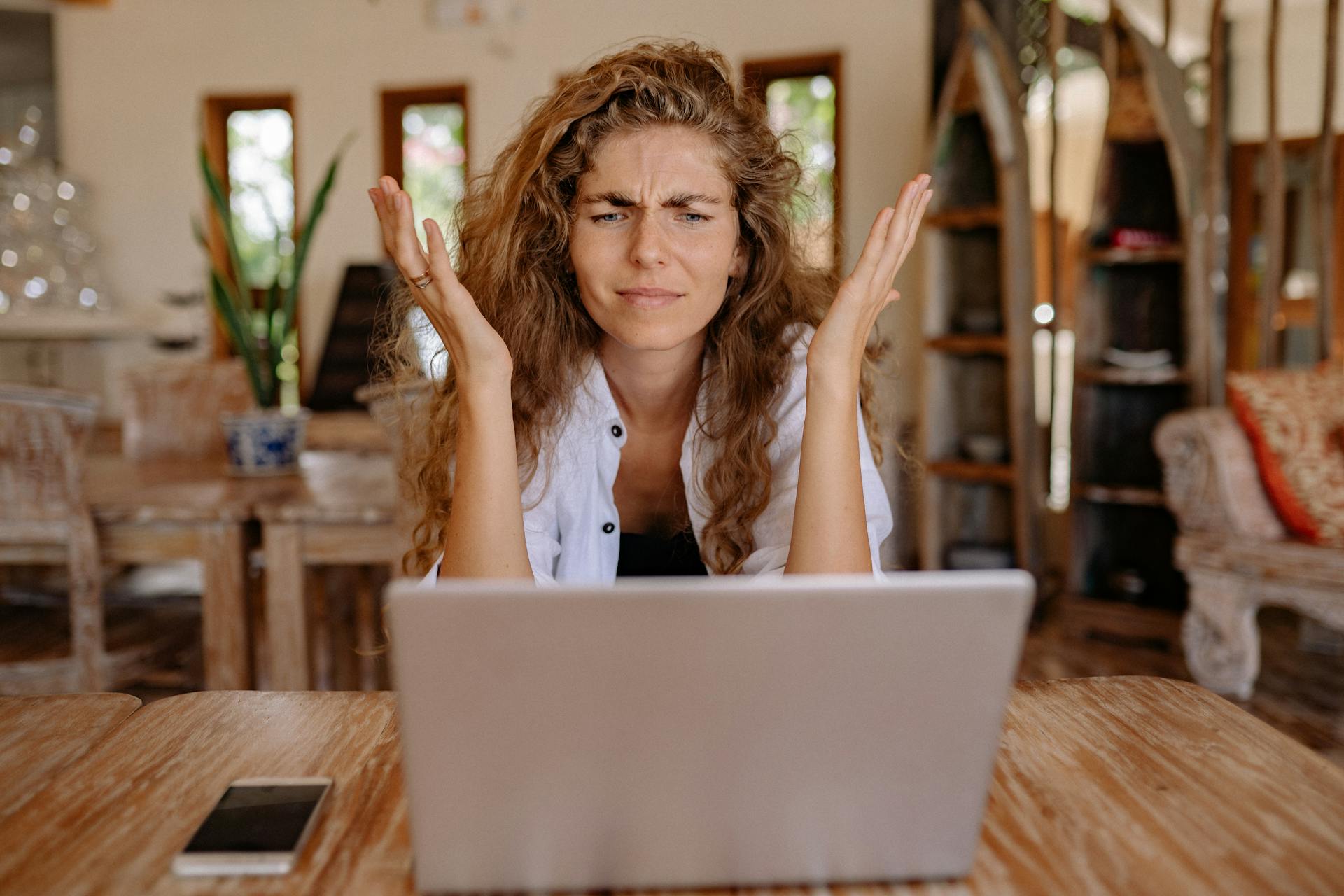Woman showing frustration while working on laptop