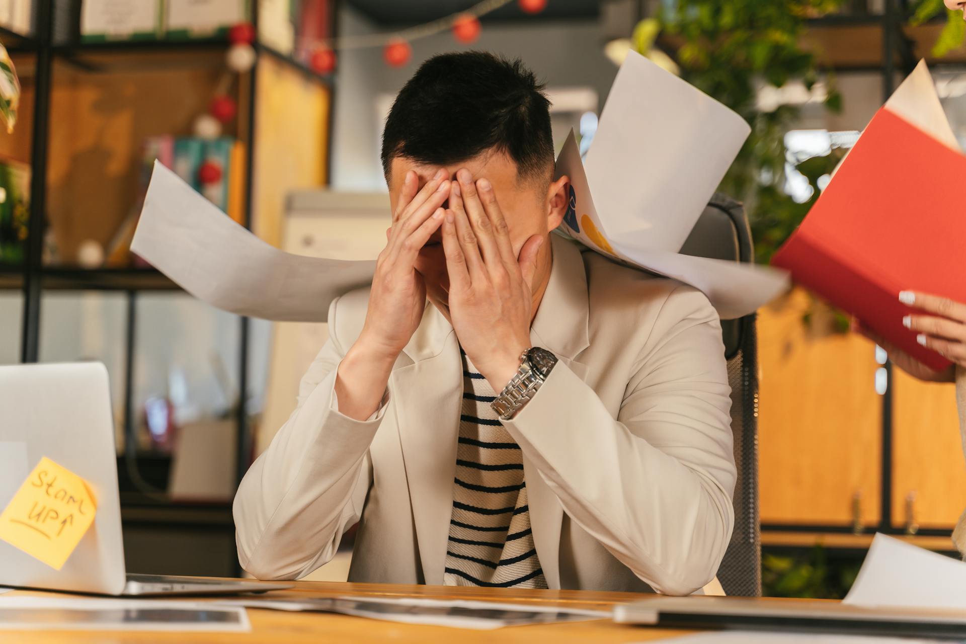 Overwhelmed businessman surrounded by paperwork and sticky notes