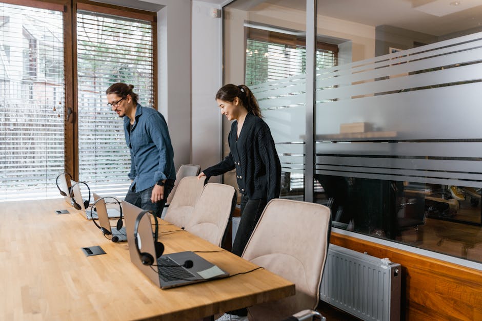 Two office employees setting up workstations together, representing a small business team getting organized with CRM tools